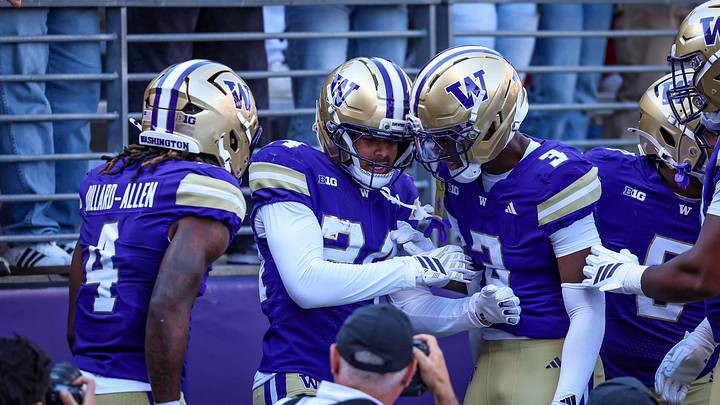 Jeron Jones is surrounded by fellow defensive backs after an Apple Cup interception. 