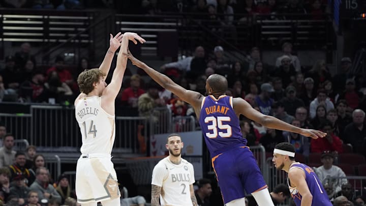 Feb 22, 2025; Chicago, Illinois, USA; Chicago Bulls forward Matas Buzelis (14) makes a three point basket as Phoenix Suns forward Kevin Durant (35) defends him during the first quarter at United Center. Mandatory Credit: David Banks-Imagn Images
