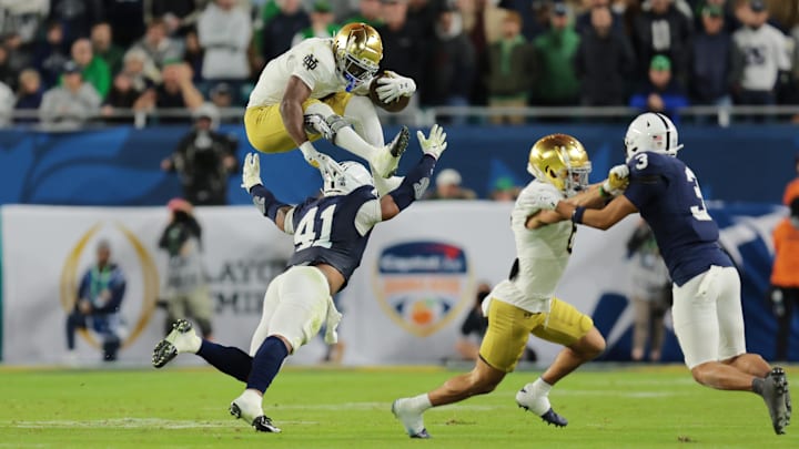 Jan 9, 2025; Miami, FL, USA; (Editors Note: Caption Correction) Notre Dame Fighting Irish running back Jeremiyah Love (4) leaps over Penn State Nittany Lions linebacker Kobe King (41) in the second half in the Orange Bowl at Hard Rock Stadium. Mandatory Credit: Sam Navarro-Imagn Images