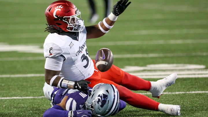 Nov 23, 2024; Manhattan, Kansas, USA; Kansas State Wildcats wide receiver Tre Spivey (12) loses the ball after being hit by Cincinnati Bearcats linebacker Simeon Coleman (31) during the third quarter at Bill Snyder Family Football Stadium. Mandatory Credit: Scott Sewell-Imagn Images