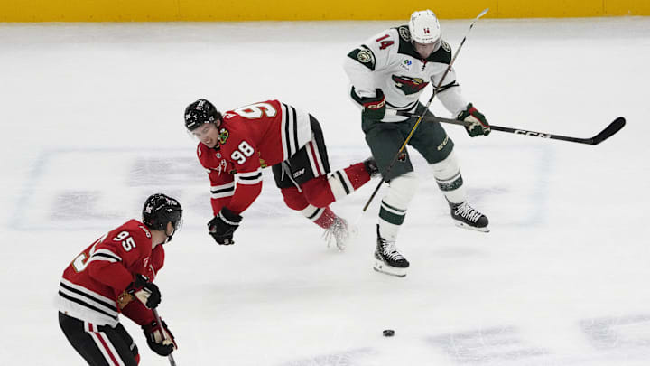 Nov 26, 2025; Chicago, Illinois, USA; Minnesota Wild center Joel Eriksson Ek (14) checks Chicago Blackhawks center Connor Bedard (98) during the third period at United Center. Mandatory Credit: David Banks-Imagn Images