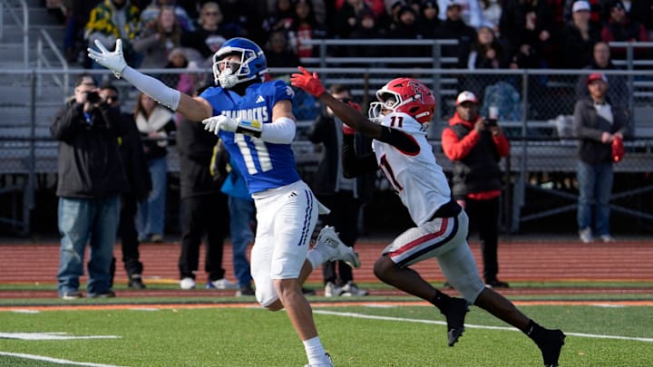 Novi Detroit Catholic Central (11) Gideon Gash stretches out on a ball thrown too high for him as East Kentwood (11) Stephan Jones defends during the first half of the MHSAA Division 1 football semifinals between Novi Detroit Catholic Central and East Kentwood at Jackson High School in Jackson on Saturday, Nov. 22, 2025.