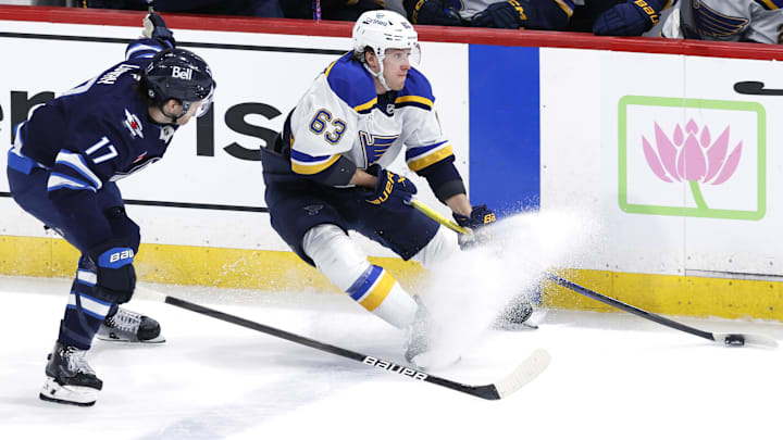 Apr 7, 2025; Winnipeg, Manitoba, CAN; St. Louis Blues left wing Jake Neighbours (63) is chased down by Winnipeg Jets center Adam Lowry (17) in the third period at Canada Life Centre. Mandatory Credit: James Carey Lauder-Imagn Images