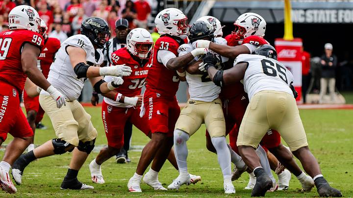 Oct 10, 2026; Raleigh, North Carolina, USA; Multiple NC State Wolfpack players attempt to tackle Wake Forest Demon Deacons wide receiver Carlos Hernandez (8) during the first half of the game at Carter-Finley Stadium. Mandatory Credit: Jaylynn Nash-Imagn Images Oct 10, 2026; Raleigh, North Carolina, USA; Multiple NC State Wolfpack players attempt to tackle Wake Forest Demon Deacons wide receiver Carlos Hernandez (8) during the first half of the game at Carter-Finley Stadium. Mandatory Credit: Jaylynn Nash-Imagn Images