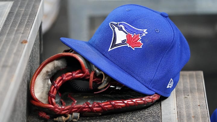 Apr 16, 2025; Toronto, Ontario, CAN; A Toronto Blue Jays hat and glove in the dugout during a game against the Atlanta Braves at Rogers Centre. Mandatory Credit: John E. Sokolowski-Imagn Images