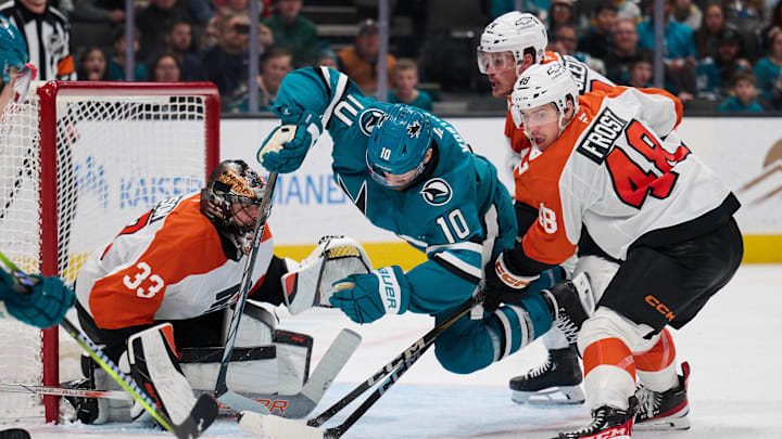 Dec 31, 2024; San Jose, California, USA; San Jose Sharks center Klim Kostin (10) is checked by Philadelphia Flyers center Morgan Frost (48) and defenseman Nick Seeler (24) as goaltender Samuel Ersson (33) protects the net during the second period at SAP Center at San Jose. Mandatory Credit: Robert Edwards-Imagn Images
