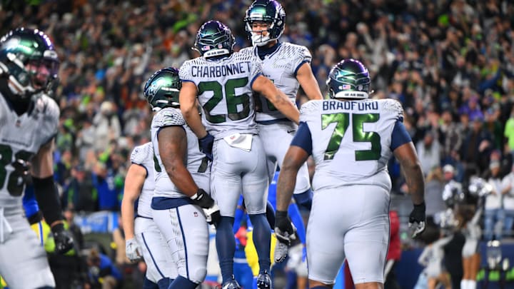 Dec 18, 2025; Seattle, Washington, USA; Seattle Seahawks running back Zach Charbonnet (26) celebrates with wide receiver Jaxon Smith-Njigba (11) after scoring a touchdown against the Los Angeles Rams in the first half at Lumen Field. Mandatory Credit: Steven Bisig-Imagn Images