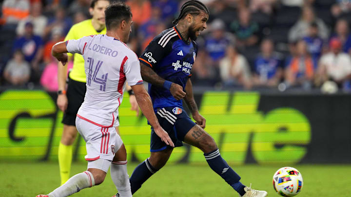Oct 5, 2024; Cincinnati, Ohio, USA; FC Cincinnati defender DeAndre Yedlin (91) passes forward as Orlando City SC midfielder Nico Lodeiro (14) defends during the second half at TQL Stadium. Mandatory Credit: Kareem Elgazzar-Imagn Images