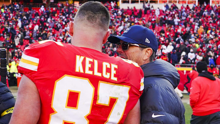 Dec 14, 2025; Kansas City, Missouri, USA; Los Angeles Chargers head coach Jim Harbaugh talks with Kansas City Chiefs tight end Travis Kelce (87) following a Chargers victory at GEHA Field at Arrowhead Stadium. Mandatory Credit: Jay Biggerstaff-Imagn Images