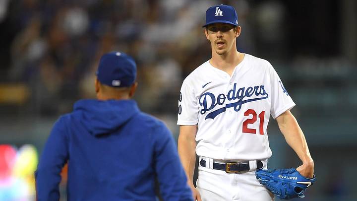 Jun 24, 2021; Los Angeles, California, USA; Los Angeles Dodgers starting pitcher Walker Buehler (21) waits on the mound for manager Dave Roberts (left) during the sixth inning against the Chicago Cubs at Dodger Stadium. Mandatory Credit: Jayne Kamin-Oncea-Imagn Images