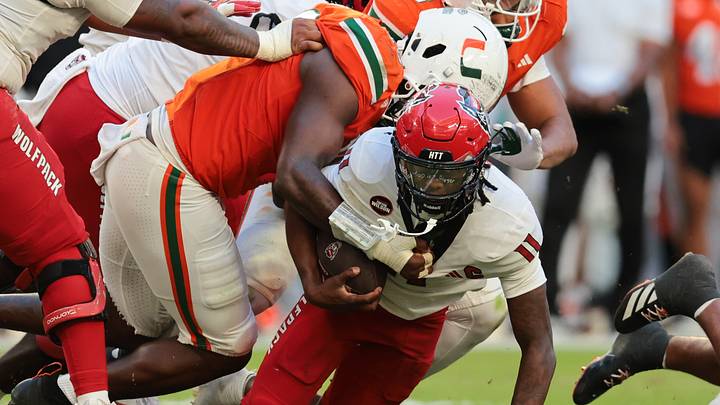 Nov 15, 2025; Miami Gardens, Florida, USA; NC State Wolfpack quarterback CJ Bailey (11) is tackled by Miami Hurricanes defensive lineman Armondo Blount (18) during the second quarter at Hard Rock Stadium. Mandatory Credit: Sam Navarro-Imagn Imagesa Nov 15, 2025; Miami Gardens, Florida, USA; NC State Wolfpack quarterback CJ Bailey (11) is tackled by Miami Hurricanes defensive lineman Armondo Blount (18) during the second quarter at Hard Rock Stadium. Mandatory Credit: Sam Navarro-Imagn Imagesa