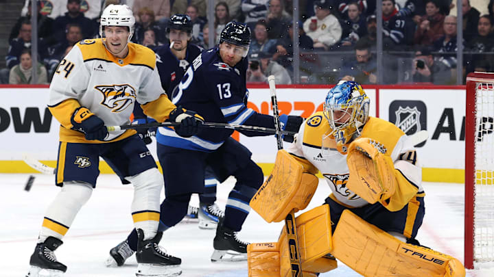 Oct 18, 2025; Winnipeg, Manitoba, CAN; Nashville Predators defenseman Spencer Stastney (24), Winnipeg Jets center Gabriel Vilardi (13) and Nashville Predators goaltender Juuse Saros (74) ate an incoming shot inthe second period at Canada Life Centre. Mandatory Credit: James Carey Lauder-Imagn Images