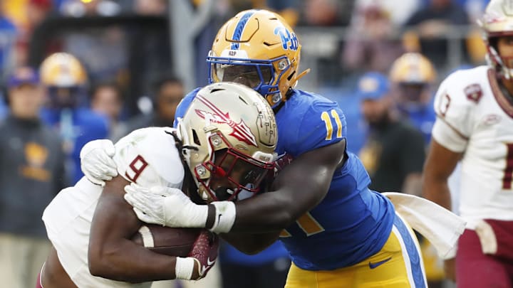 Nov 4, 2023; Pittsburgh, Pennsylvania, USA;  Pittsburgh Panthers linebacker Bangally Kamara (11) tackles Florida State Seminoles running back Lawrance Toafili (9) in the backfield during the second quarter at Acrisure Stadium. Mandatory Credit: Charles LeClaire-Imagn Images