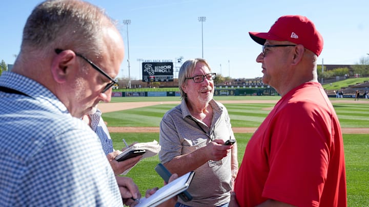 Sports Reporter Gary Schatz, along with other members of the press, interviews Cincinnati Reds manager Terry Francona (77) after a 3-2 win against the Chicago White Sox during a Cactus League game, Wednesday, Feb. 25, 2026, at Camelback Ranch Stadium in Glendale, Ariz.