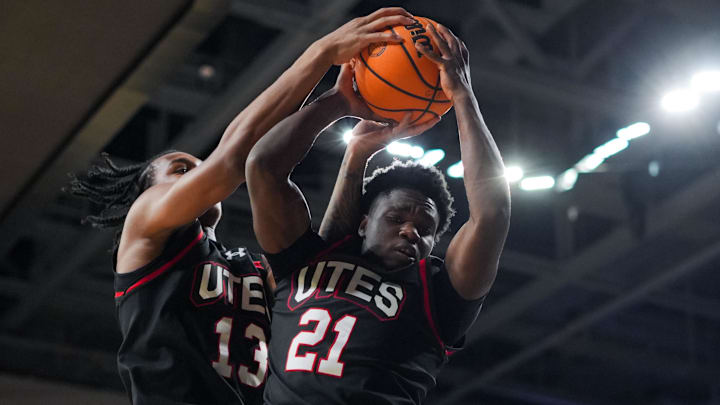 Utah Runnin' Utes guard Obomate Abbey (21) grabs a rebound as he collides with forward Kendyl Sanders (13) during the game against the Cincinnati Bearcats in the first at Fifth Third Arena.