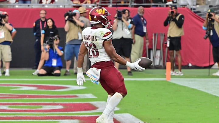 Sep 29, 2024; Glendale, Arizona, USA;  Washington Commanders running back Jeremy McNichols (26) scores a touchdown  in the second half against the Arizona Cardinals at State Farm Stadium. Mandatory Credit: Matt Kartozian-Imagn Images