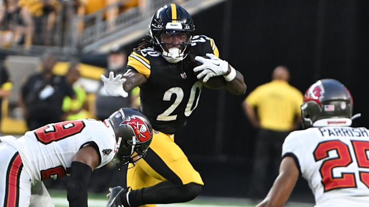 Aug 16, 2025; Pittsburgh, Pennsylvania, USA; Pittsburgh Steelers running back Kaleb Johnson (20) looks to stiff arm Tampa Bay Buccaneers safety Christian Izien (29) during the second quarter at Acrisure Stadium. Mandatory Credit: Barry Reeger-Imagn Images