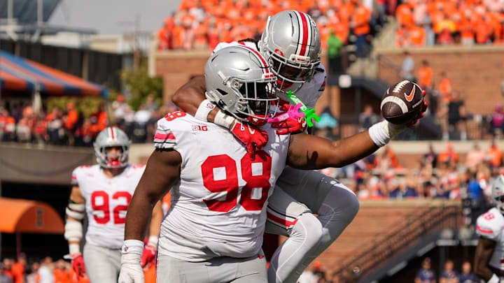 Ohio State Buckeyes defensive lineman Kayden McDonald (98) celebrates a fumble recovery with cornerback Jermaine Mathews Jr. (7) after stripping the ball from Illinois Fighting Illini running back Ca'Lil Valentine (5) during the first half of the NCAA football game at Gies Memorial Stadium in Champaign on Oct. 11, 2025.