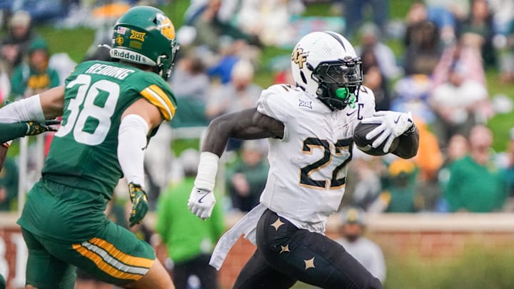 Nov 1, 2025; Waco, Texas, USA; UCF Knights running back Myles Montgomery (22) carries the ball as Baylor Bears safety Jacob Redding (38) defends during the first half at McLane Stadium. Mandatory Credit: Raymond Carlin III-Imagn Images