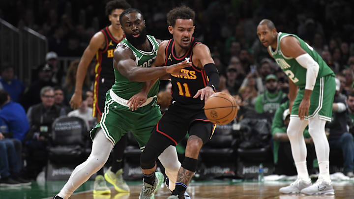 Feb 7, 2024; Boston, Massachusetts, USA;  Boston Celtics guard Jaylen Brown (7) tries to steal the ball from Atlanta Hawks guard Trae Young (11) during the second half at TD Garden. Mandatory Credit: Bob DeChiara-Imagn Images