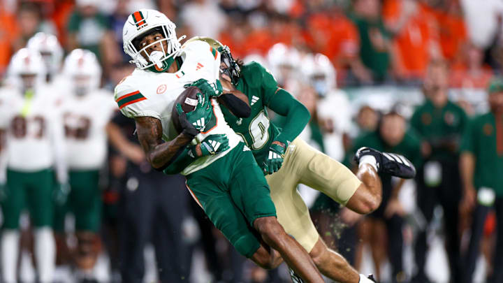 Sep 21, 2024; Tampa, Florida, USA; Miami Hurricanes wide receiver Jacolby George (3) is tackled by South Florida Bulls cornerback Brent Austin (20) in the first quarter at Raymond James Stadium. Mandatory Credit: Nathan Ray Seebeck-Imagn Images