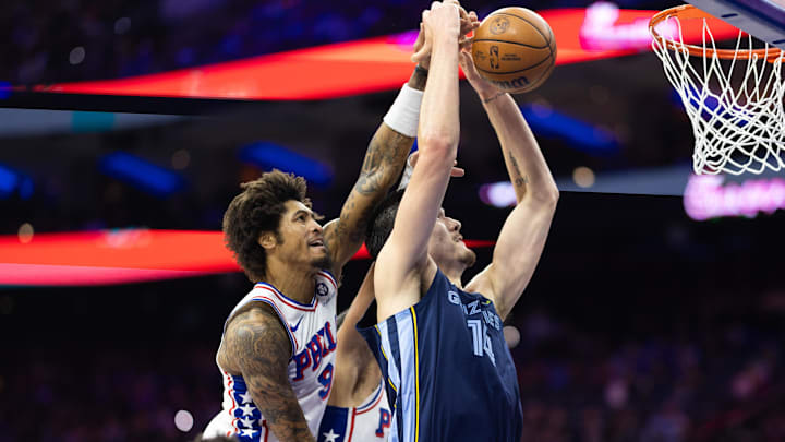 Nov 2, 2024; Philadelphia, Pennsylvania, USA; Philadelphia 76ers guard Kelly Oubre Jr. (9) blocks the drive of Memphis Grizzlies center Zach Edey (14) during the third quarter at Wells Fargo Center. Mandatory Credit: Bill Streicher-Imagn Images
