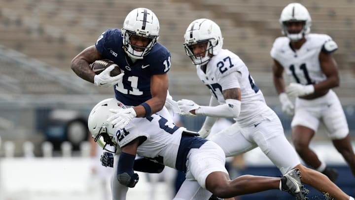 Penn State Nittany Lions wide receiver Kyron Hudson (11) runs with the ball as safety Vaboue Toure (21) goes for the tackle during the Blue-White Game. 