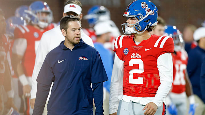 Oct 28, 2023; Oxford, Mississippi, USA; Mississippi Rebels offensive coordinator Charlie Weis Jr. (left) talks with quarterback Jaxson Dart (2) during warm ups prior to the game against the Vanderbilt Commodores at Vaught-Hemingway Stadium. Mandatory Credit: Petre Thomas-Imagn Images