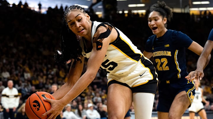 Iowa forward Hannah Stuelke (45) tries to keep a basketball in bounds as Michigan guard Kendall Dudley (22) defends Feb. 22, 2026 at Carver-Hawkeye Arena in Iowa City, Iowa.