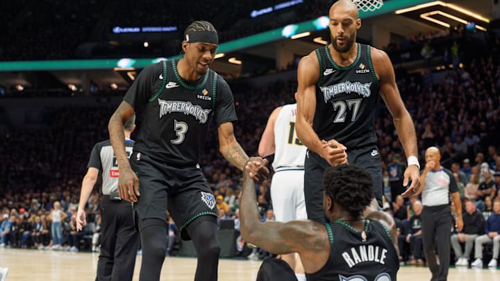 Apr 25, 2026; Minneapolis, Minnesota, USA; Minnesota Timberwolves center Rudy Gobert (27) and forward Jaden McDaniels (3) help up forward Julius Randle (30) after a foul by the Denver Nuggets in the first quarter at Target Center.