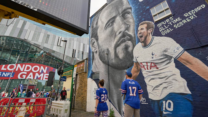 Oct 8, 2023; London, United Kingdom; Fans walk past a painted walll picture of record soccer goal scorer Harry Kane next to the stadium of an NFL International Series game at Tottenham Hotspur Stadium. Mandatory Credit: Peter van den Berg-Imagn Images