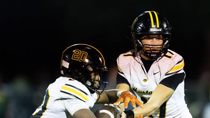 Merritt Island Mustangs Alain Adams (20) takes a hand off from Merritt Island Mustangs Kevin Verpaele (17) in the third quarter. Ed White Commanders (4-0) hosted Merritt Island Mustangs (3-2) at Ed White High School School in Jacksonville, Fla. Friday September 26, 2025. [Doug Engle/Florida Times-Union]