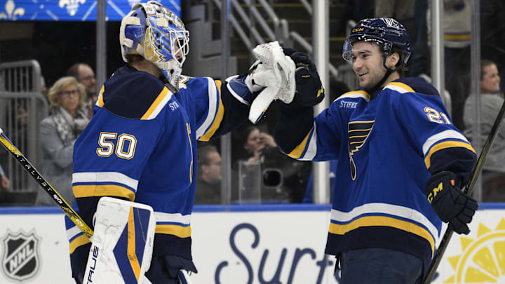 Apr 15, 2025; St. Louis, Missouri, USA; St. Louis Blues right wing Jimmy Snuggerud (21) and goaltender Jordan Binnington (50) celebrate a win against the Utah Hockey Club at Enterprise Center to clinch a spot in the playoffs. Mandatory Credit: Jeff Le-Imagn Images