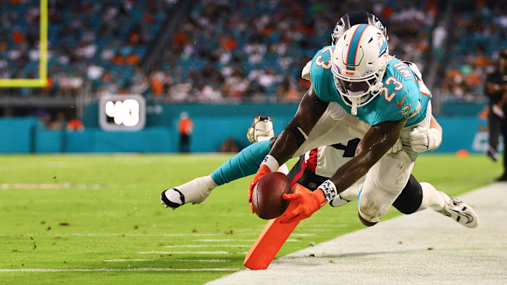 Aug 9, 2024; Miami Gardens, Florida, USA; Miami Dolphins running back Jeff Wilson Jr. (23) scores a touchdown against Atlanta Falcons linebacker JD Bertrand (40) during the second quarter at Hard Rock Stadium. Mandatory Credit: Sam Navarro-Imagn Images