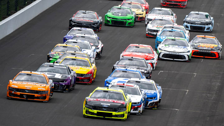 The pack of cars head into the first turn after a restart with only four laps left in the second stage of racing Sunday, July 27, 2025, during the Brickyard 400 at Indianapolis Motor Speedway.