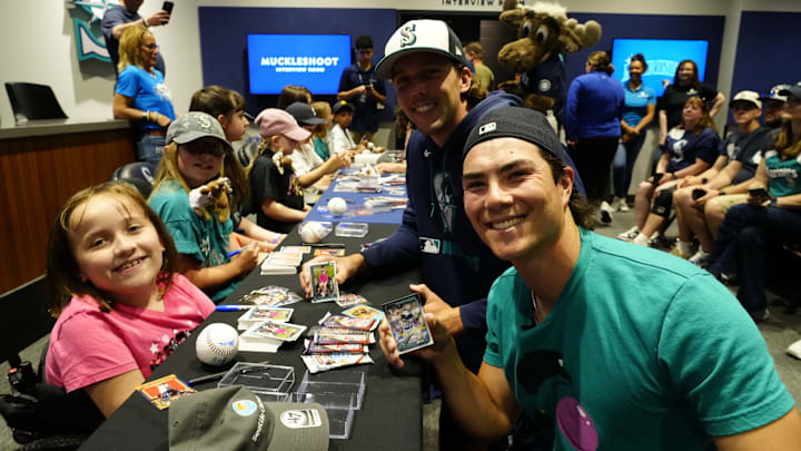Seattle Mariners starting pitchers Bryan Woo (front right) and Logan Gilbert (middle right) take part in a reverse signing event with Seattle Children's Hospital on June 17 at T-Mobile Park.