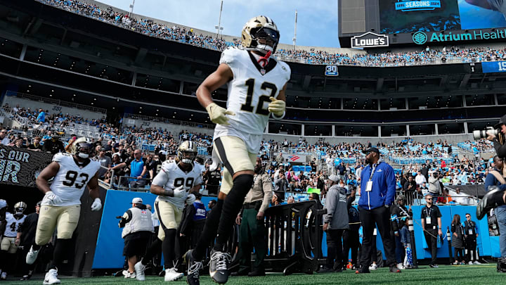 Nov 3, 2024; Charlotte, North Carolina, USA; New Orleans Saints wide receiver Chris Olave (12) runs on to the field before the game at Bank of America Stadium. Mandatory Credit: Bob Donnan-Imagn Images