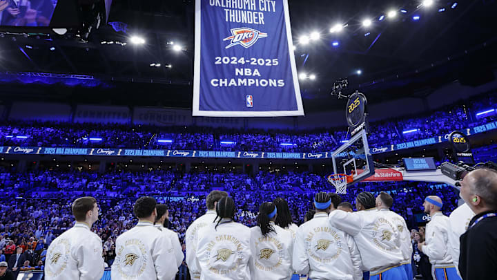 Oct 21, 2025; Oklahoma City, Oklahoma, USA; Oklahoma City Thunder team members watch as their NBA Championship banner rises before the start of a game against the Houston Rockets at Paycom Center. Mandatory Credit: Alonzo Adams-Imagn Images