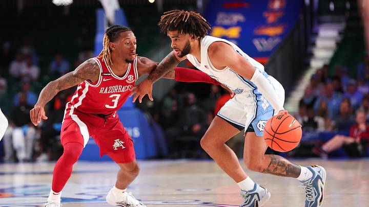 Nov 24, 2023; Paradise Island, BAHAMAS; North Carolina Tar Heels guard RJ Davis (4) controls the ball as Arkansas Razorbacks guard El Ellis (3) defends during the first half at Imperial Arena. Mandatory Credit: Kevin Jairaj-Imagn Images