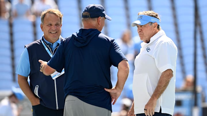 Sep 13, 2025; Chapel Hill, North Carolina, USA; Richmond Spiders head coach Russ Huesman talks to North Carolina Tar Heels general manger Michael Lombardi and head coach Bill Belichick before the game at Kenan Stadium. Mandatory Credit: Bob Donnan-Imagn Images Sep 13, 2025; Chapel Hill, North Carolina, USA; Richmond Spiders head coach Russ Huesman talks to North Carolina Tar Heels general manger Michael Lombardi and head coach Bill Belichick before the game at Kenan Stadium. Mandatory Credit: Bob Donnan-Imagn Images