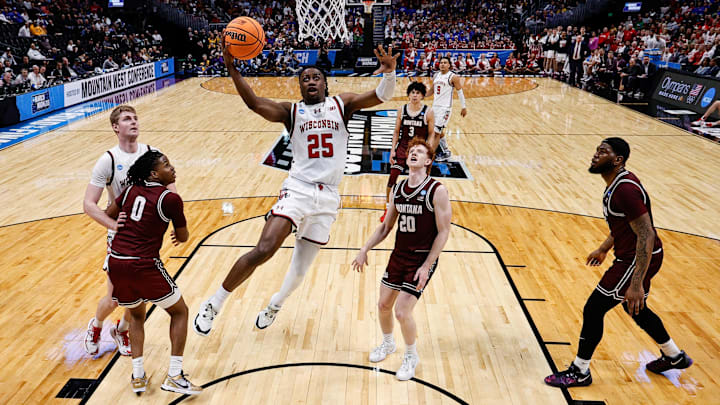 Mar 20, 2025; Denver, CO, USA; Wisconsin Badgers guard John Blackwell (25) drives to the net as Montana Grizzlies guard Money Williams (0) defends against forward Steven Crowl (22) and guard Austin Patterson (20) and forward Te'Jon Sawyer (32) defend in the first half at Ball Arena. Mar 20, 2025; Denver, CO, USA; Wisconsin Badgers guard John Blackwell (25) drives to the net as Montana Grizzlies guard Money Williams (0) defends against forward Steven Crowl (22) and guard Austin Patterson (20) and forward Te'Jon Sawyer (32) defend in the first half at Ball Arena.