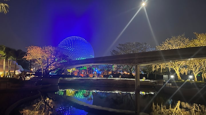 EPCOT'S Spaceship Earth glows blue under a full moon. Image courtesy Brian Miller