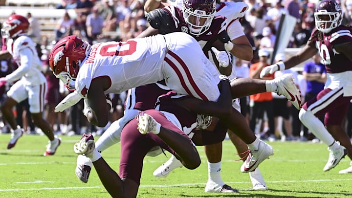 Oct 26, 2024; Starkville, Mississippi, USA; Arkansas Razorbacks running back Braylen Russell (0) is tackled by Mississippi State Bulldogs cornerback Brice Pollock (14) during the second quarter at Davis Wade Stadium at Scott Field. Mandatory Credit: Matt Bush-Imagn Images
