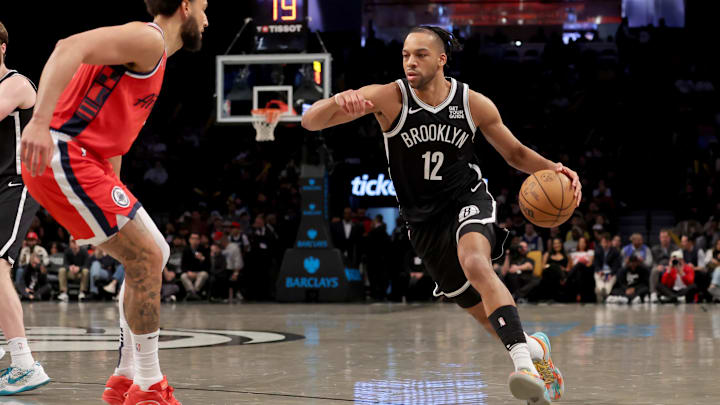 Mar 28, 2025; Brooklyn, New York, USA; Brooklyn Nets forward Tosan Evbuomwan (12) drives to the basket against Los Angeles Clippers guard Ben Simmons (25) during the fourth quarter at Barclays Center. Mandatory Credit: Brad Penner-Imagn Images