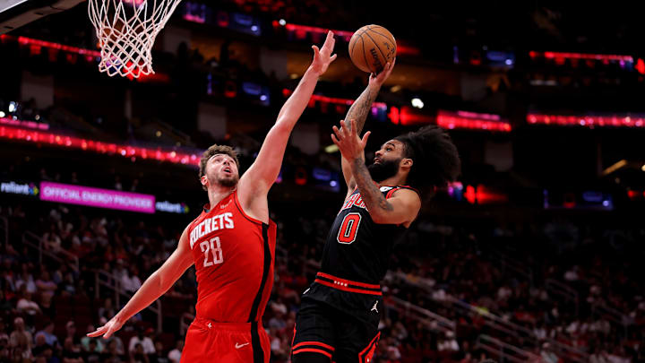 Mar 15, 2025; Houston, Texas, USA; Chicago Bulls guard Coby White (0) drives to the basket against Houston Rockets center Alperen Sengun (28) during the second quarter at Toyota Center. Mandatory Credit: Erik Williams-Imagn Images