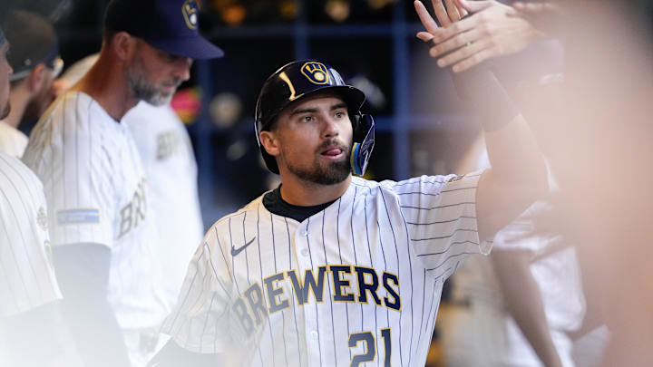 Aug 24, 2025; Milwaukee, Wisconsin, USA;  Milwaukee Brewers third baseman Caleb Durbin (21) high fives teammates in the dugout after scoring a run during the third inning against the San Francisco Giants at American Family Field. Mandatory Credit: Jeff Hanisch-Imagn Images