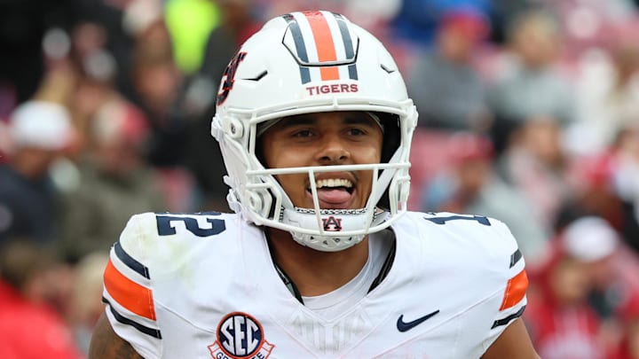 Oct 25, 2025; Fayetteville, Arkansas, USA; Auburn Tigers quarterback Ashton Daniels (12) celebrates after scoring a two point conversion during the fourth quarter against the Arkansas Razorbacks at Donald W. Reynolds Razorback Stadium. Auburn won 33-24. Mandatory Credit: Nelson Chenault-Imagn Images