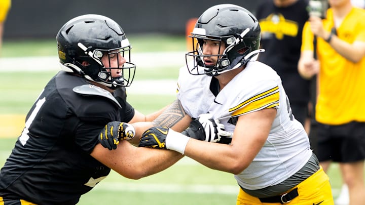 Aug 9, 2025; Iowa offensive lineman Jack Dotzler, left, blocks against defensive lineman Iose Epenesa during the Hawkeyes Kids Day NCAA football open practice at Kinnick Stadium in Iowa City, Iowa. Mandatory Credit: Joseph Cress for the Des Moines Register