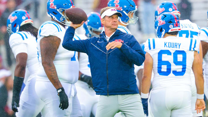 Oct 25, 2025; Norman, Oklahoma, USA;  Ole Miss Rebels head coach Lane Kiffin throws a football before the game against the Oklahoma Sooners at Gaylord Family-Oklahoma Memorial Stadium. Mandatory Credit: Kevin Jairaj-Imagn Images