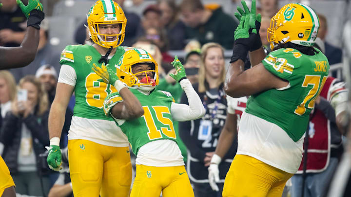 Jan 1, 2024; Glendale, AZ, USA; Oregon Ducks wide receiver Tez Johnson (15) celebrates with offensive lineman Steven Jones (74) and tight end Patrick Herbert (88) after scoring a touchdown against the Liberty Flames during the second half in the 2024 Fiesta Bowl at State Farm Stadium. Mandatory Credit: Mark J. Rebilas-USA TODAY Sports